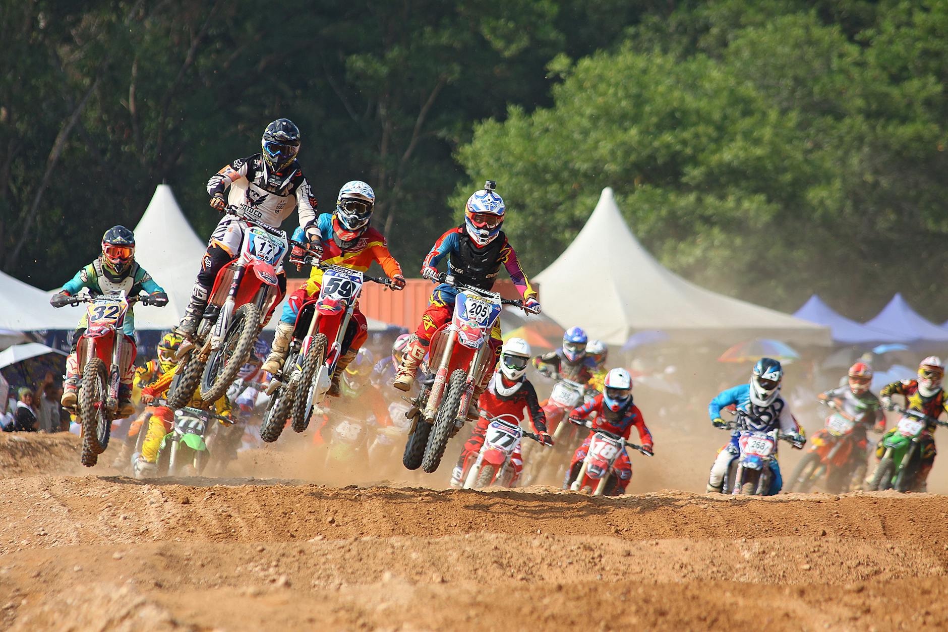 Pilotos de motocross em plena ação competindo e enfrentando desafios com foco e preparo mental.